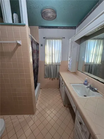 a spacious bathroom with a granite countertop sink and a mirror