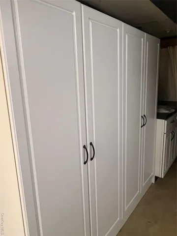 a view of a closet area with wooden floor