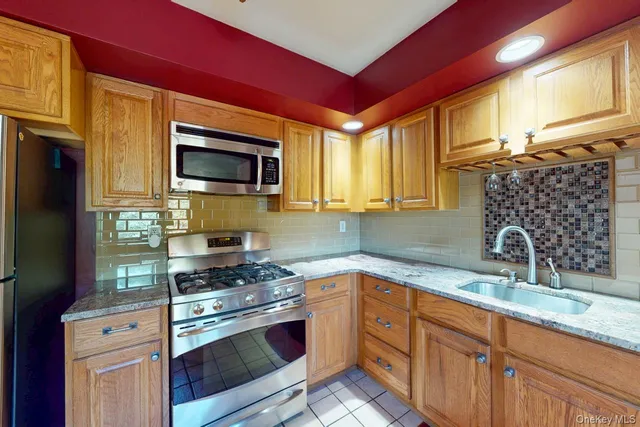 a kitchen with granite countertop a sink stainless steel appliances and cabinets