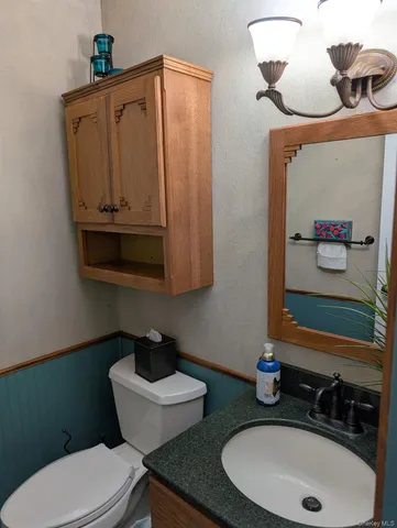 a bathroom with a toilet sink and mirror