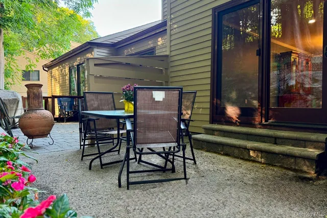 a patio with table and chairs and potted plants