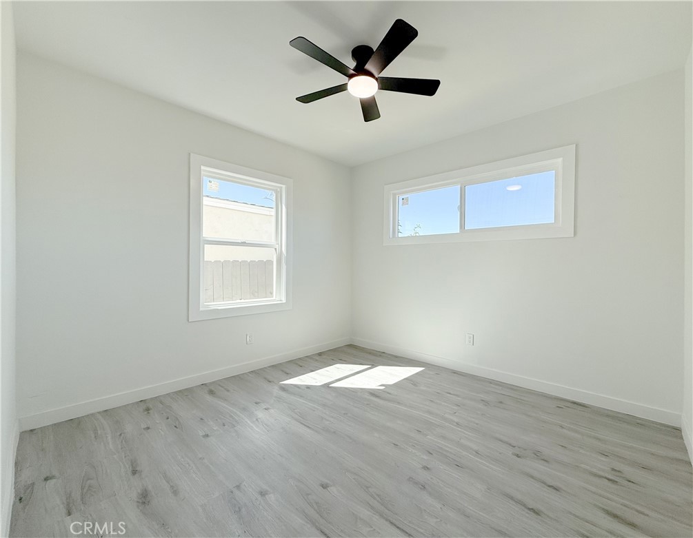511 North Albertson Avenue Compton, CA 90220 - Photo 12 of 25 a view of an empty room with wooden floor and a ceiling fan