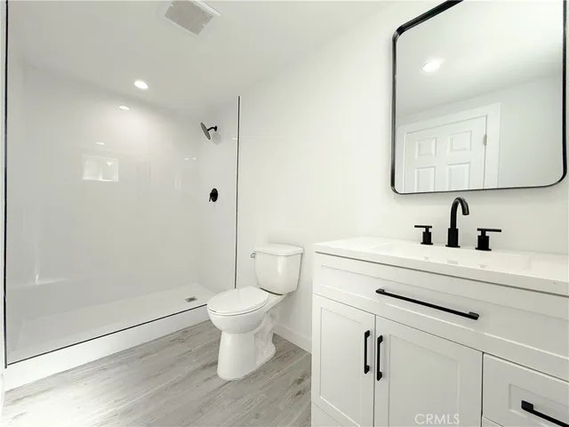a bathroom with a sink toilet a mirror and shower