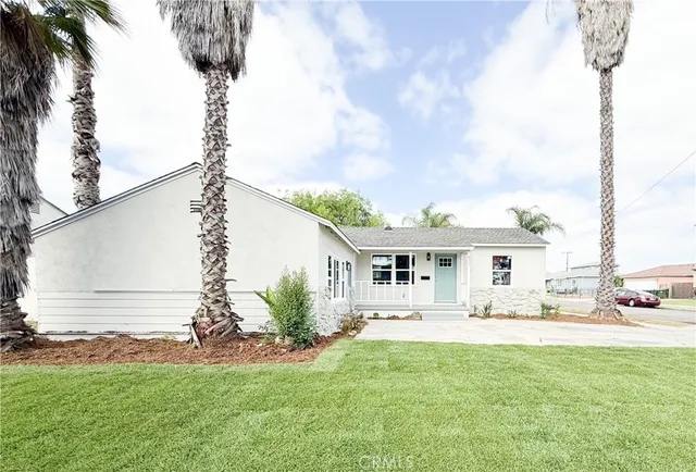 a front view of a house with a garden and yard