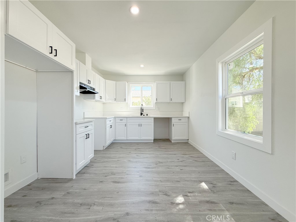 511 North Albertson Avenue Compton, CA 90220 - Photo 4 of 25 a view of a kitchen with white cabinets and wooden floor