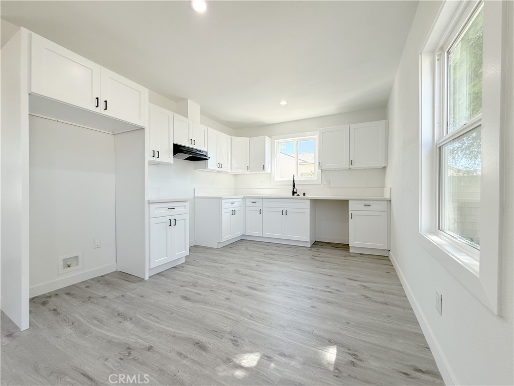 511 North Albertson Avenue Compton, CA 90220 - Photo 6 of 25 a kitchen with white cabinets and wooden floors