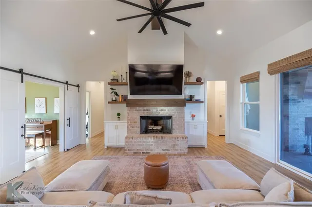 a living room with furniture a flat screen tv and a fireplace