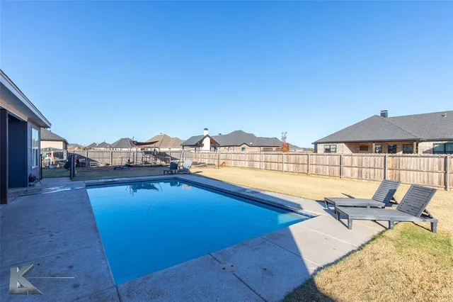 a view of a house with swimming pool and sitting area
