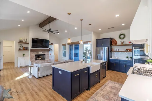 a large kitchen with stainless steel appliances a large center island and a stove