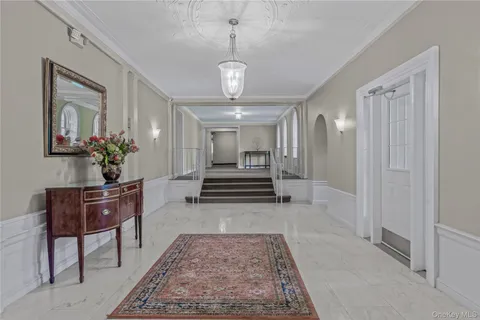 a view of a hallway with wooden floor and a chandelier