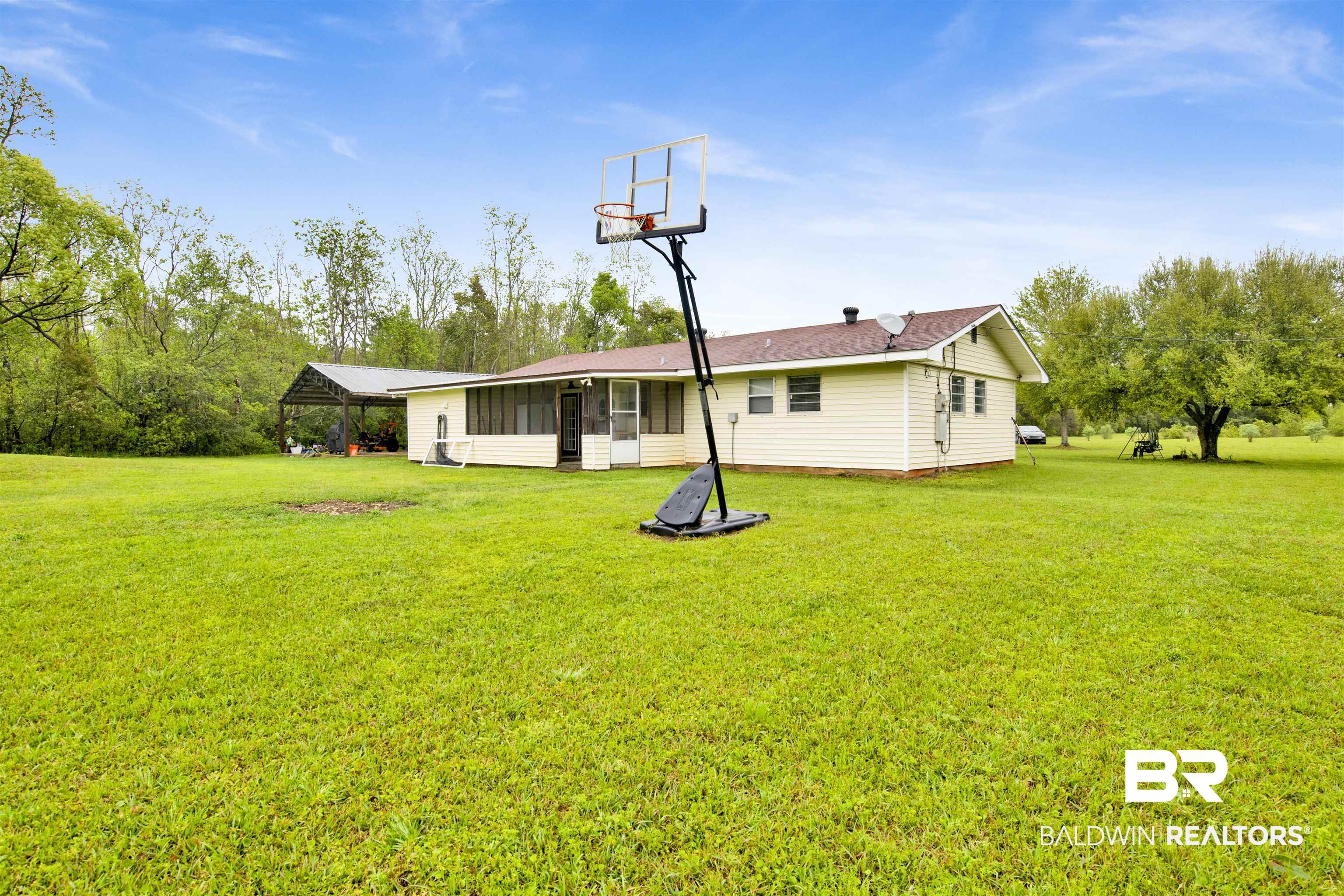 10244 Magnolia Road Irvington, AL 36544 - Photo 29 of 37 Rear view of house featuring a sunroom and a yard