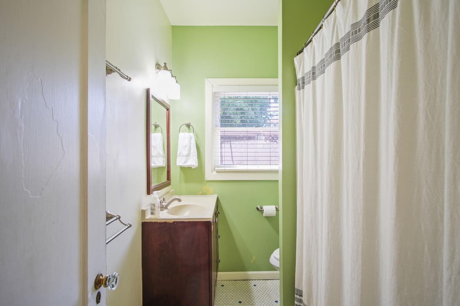 930 West Harding Way Stockton, CA 95203 - Photo 11 of 22 a bathroom with a sink a toilet and a mirror