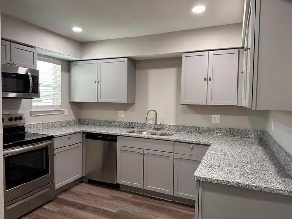 a kitchen with granite countertop cabinets stainless steel appliances and sink