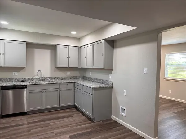 a kitchen with granite countertop a sink and cabinets