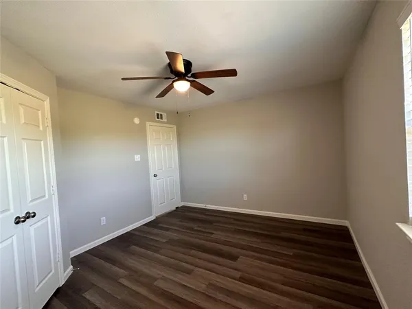 a view of room with wooden floor and ceiling fan