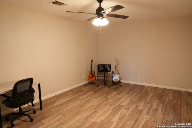 a view of workspace with wooden floor and fan