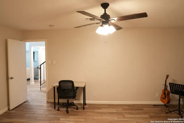 a view of a workspace with furniture and wooden floor