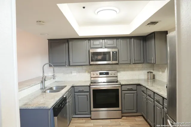 a kitchen with stainless steel appliances granite countertop a sink stove and microwave