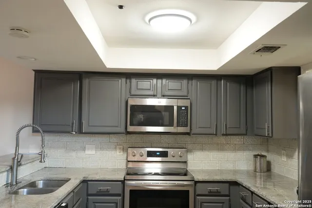 a kitchen with a sink and a stove top oven