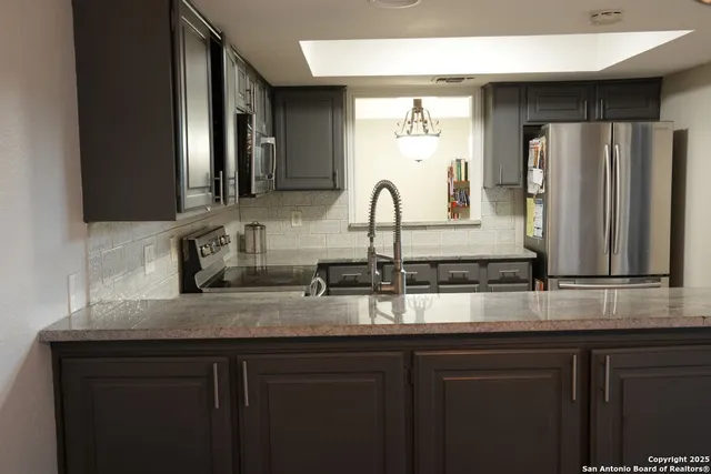 a kitchen with sink and mirror