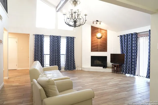 a living room with furniture a fireplace and a chandelier
