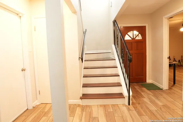 a view of a bedroom with wooden floor and staircase