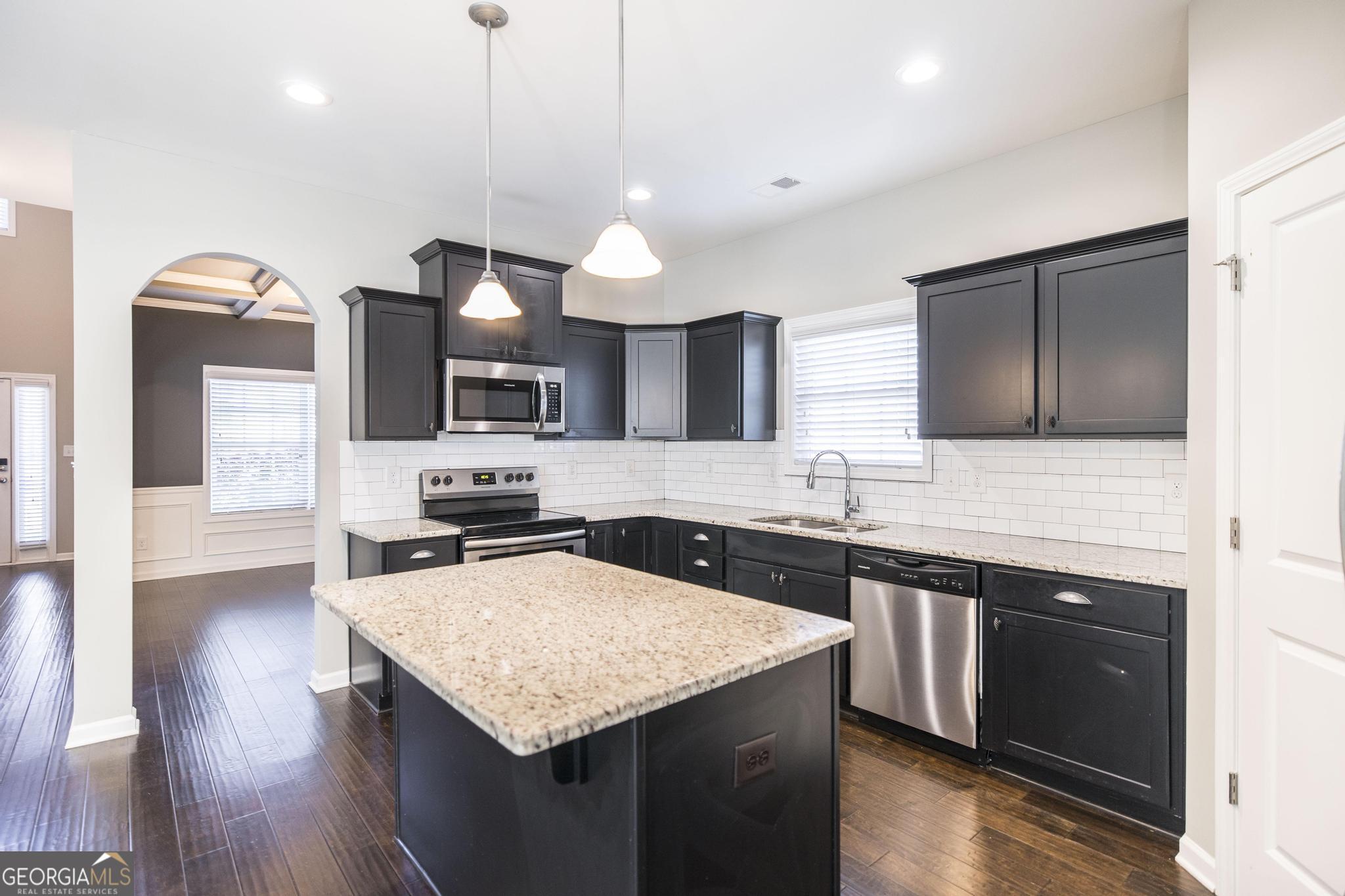 104 Goldenrod Trail Perry, GA 31069 - Photo 11 of 35 a kitchen with a sink a microwave a stove and refrigerator