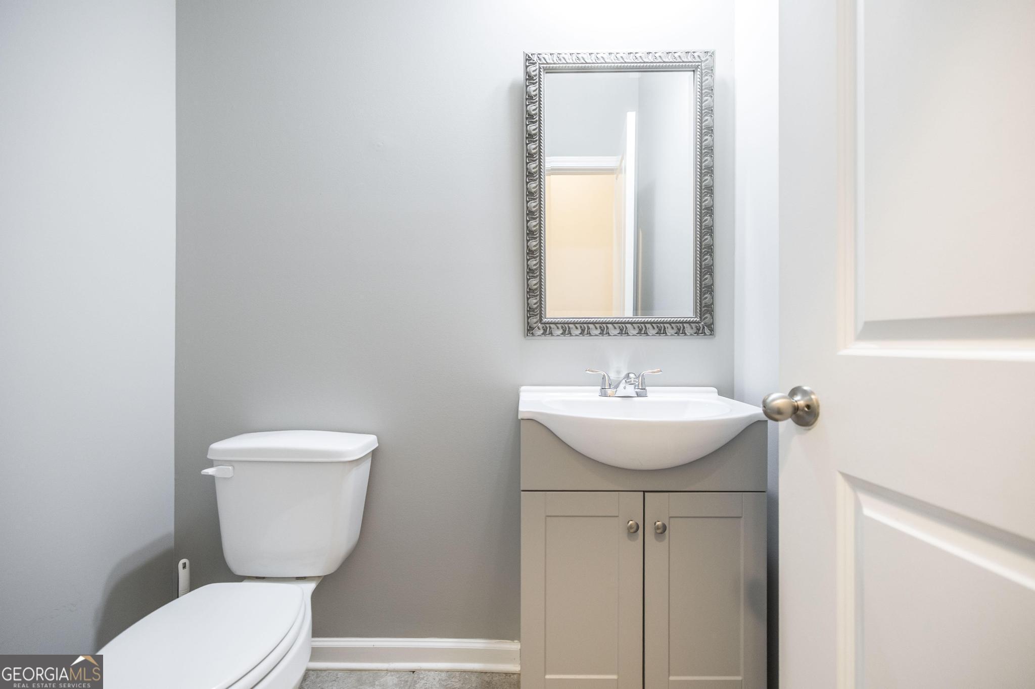104 Goldenrod Trail Perry, GA 31069 - Photo 16 of 35 a bathroom with a toilet sink and mirror