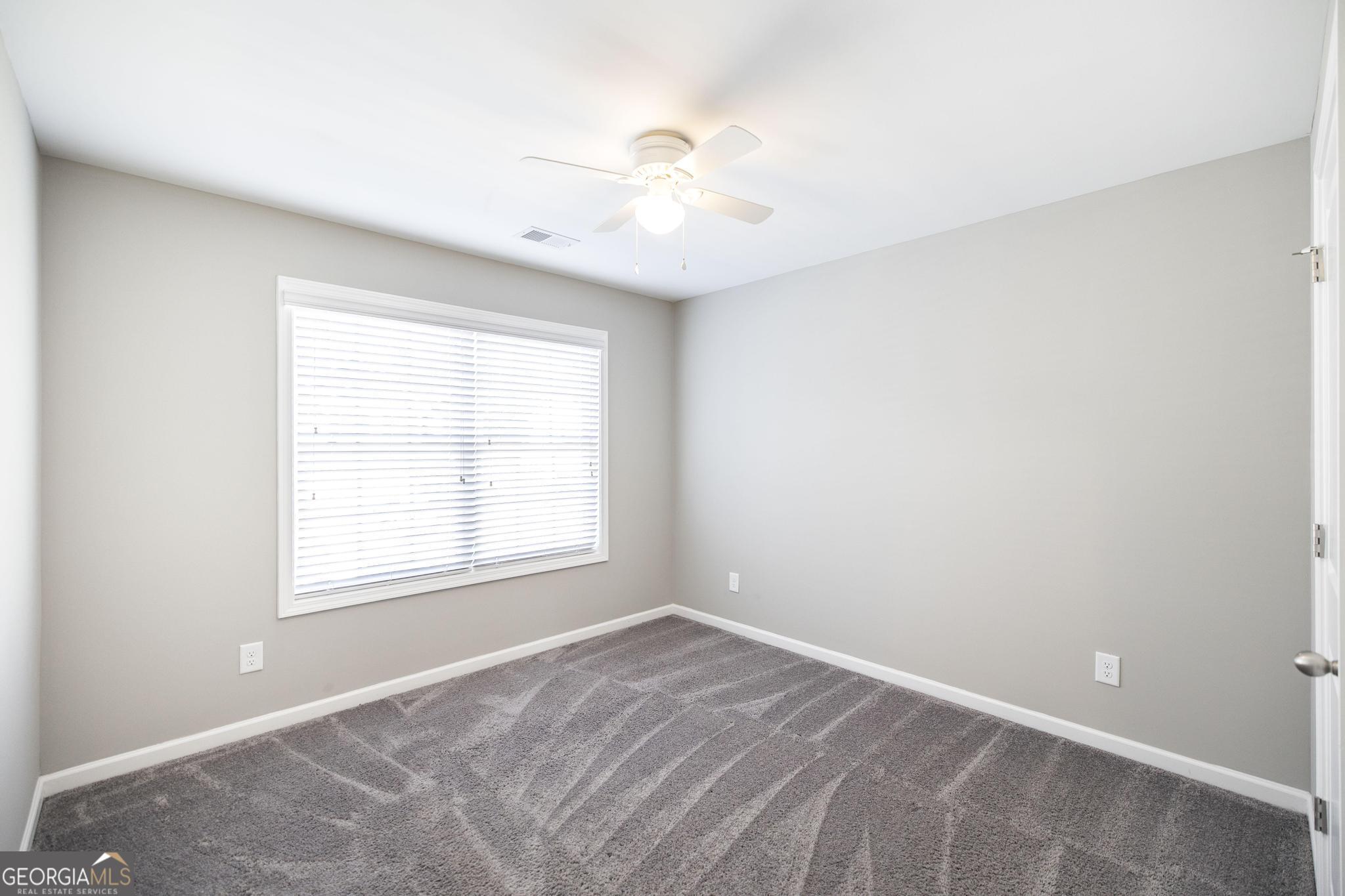 104 Goldenrod Trail Perry, GA 31069 - Photo 19 of 35 an empty room with a window and a fan