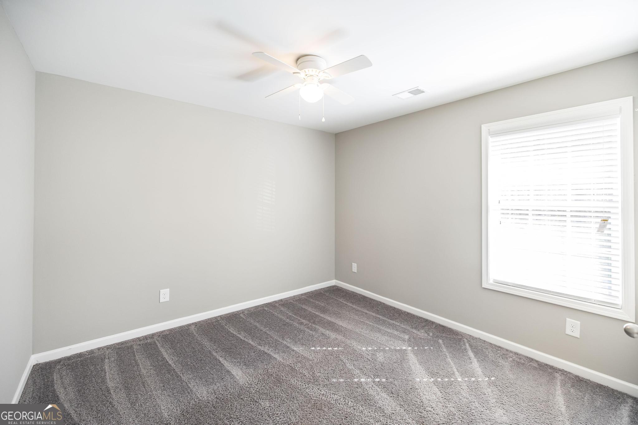 104 Goldenrod Trail Perry, GA 31069 - Photo 22 of 35 an empty room with a window and a fan