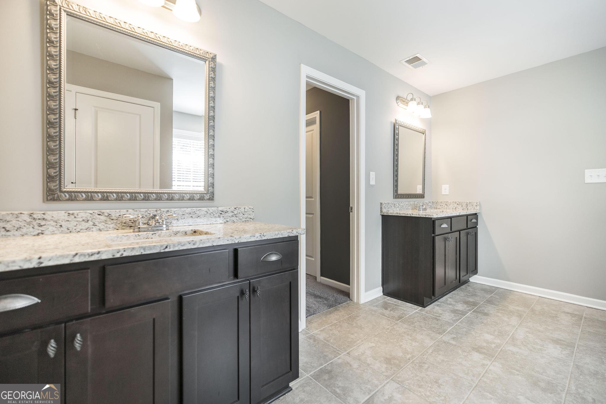 104 Goldenrod Trail Perry, GA 31069 - Photo 30 of 35 a bathroom with a granite countertop sink and mirror