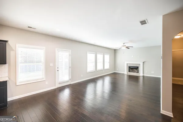 a view of a kitchen with wooden floor and a kitchen space with a sink
