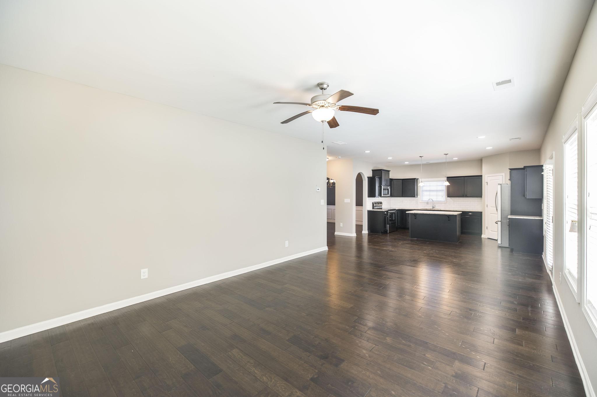 104 Goldenrod Trail Perry, GA 31069 - Photo 9 of 35 a view of a kitchen with wooden floor and a kitchen space with a sink