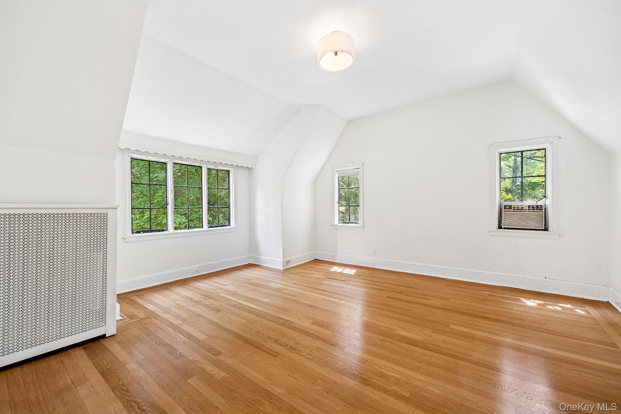 10 River Road Scarsdale, NY 10583 - Photo 19 of 20 Additional bedroom in attic l featuring lofted ceiling, radiator heating unit, and light wood-style floors
