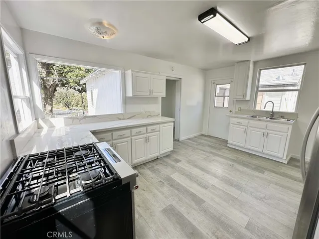 a kitchen with stainless steel appliances granite countertop a stove a sink and a refrigerator