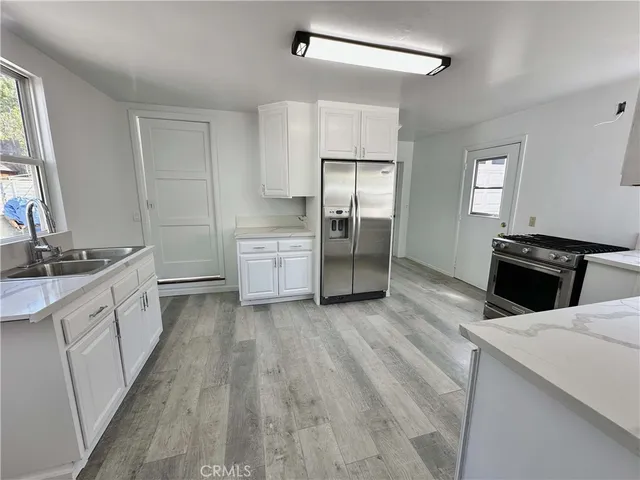 a kitchen with stainless steel appliances a stove refrigerator and cabinets