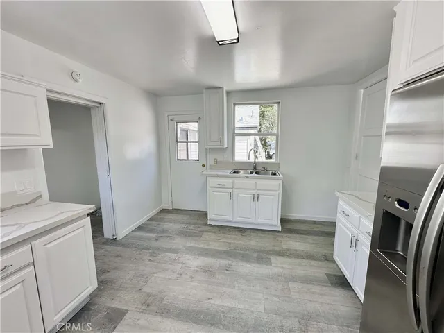a view of a kitchen with refrigerator and window