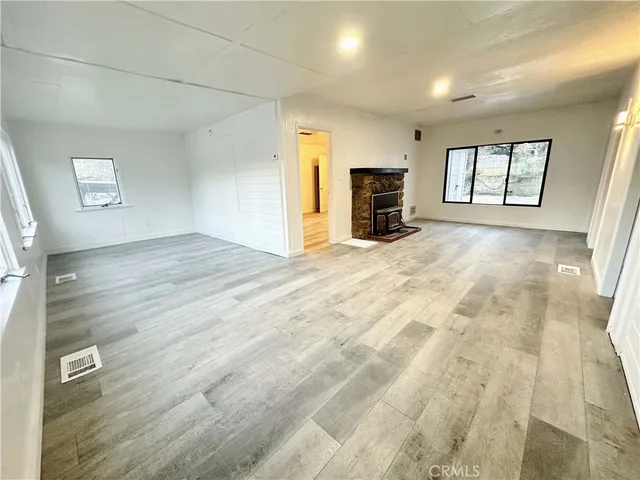 a view of empty room with a fireplace and a window