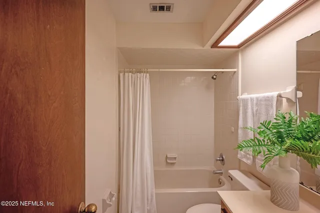 a bathroom with a shower curtain and a tub