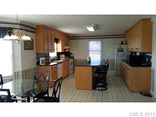 1344 Bowers Road Peachland, NC 28133 - Photo 3 of 15 a kitchen with stainless steel appliances a sink a stove a refrigerator cabinets and a dining table