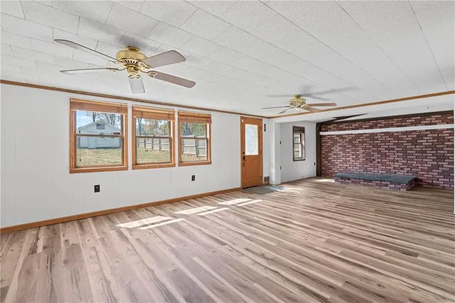 a view of empty room with wooden floor and a ceiling fan