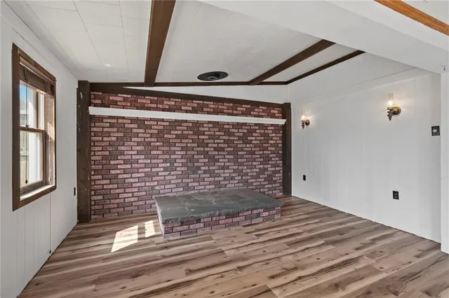 a view of a big room with wooden floor and windows