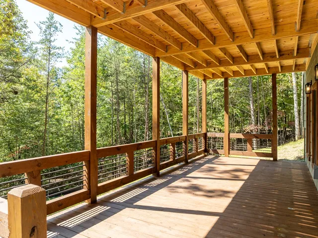 a view of a house with wooden deck and furniture