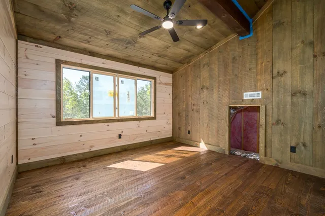 a view of a livingroom with a chandelier fan and a window