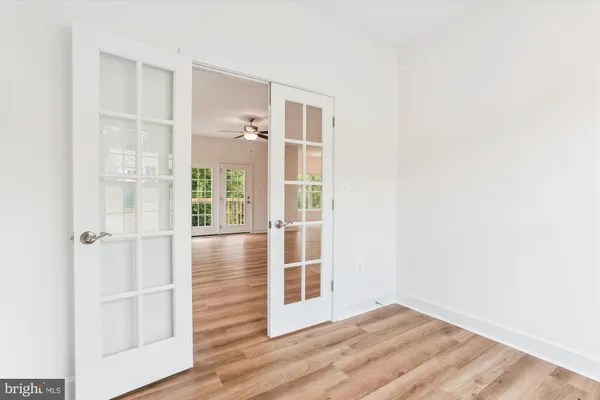 an empty room with wooden floor cabinet and windows