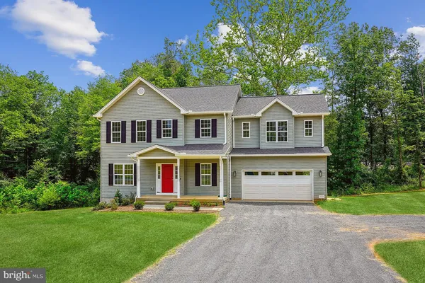 a front view of a house with a yard and trees