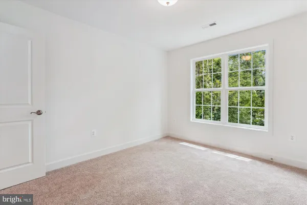 an empty room with windows and ceiling fan view