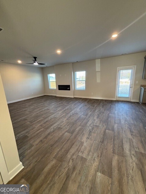 346 Jarrett Street, Unit 56 Fairburn, GA 30213 - Photo 4 of 25 an empty room with wooden floor and windows