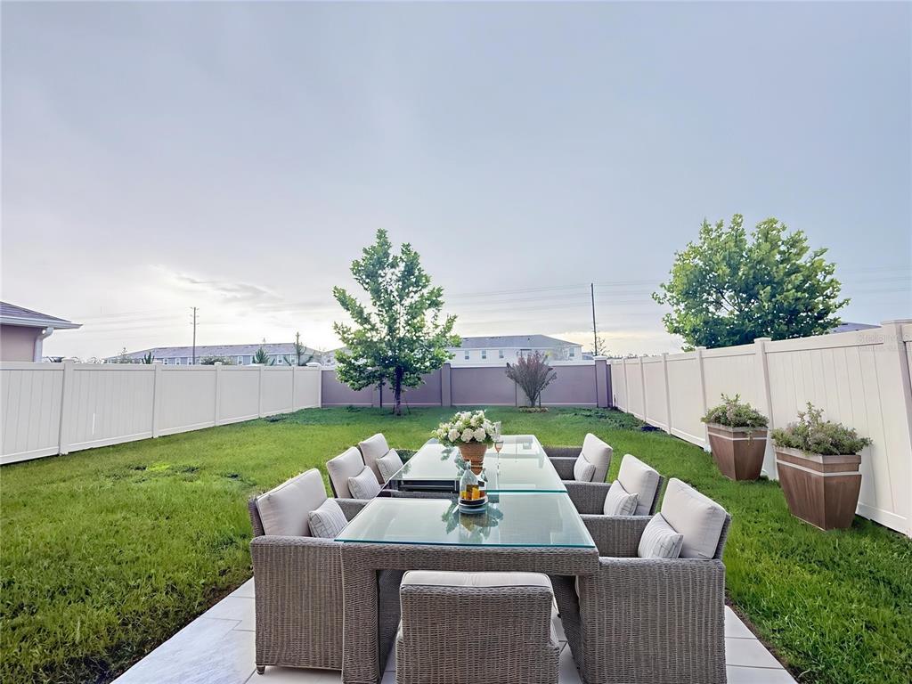 9176 Forge Breeze Loop Wesley Chapel, FL 33545 - Photo 23 of 33 a view of a patio with couches chairs and a yard