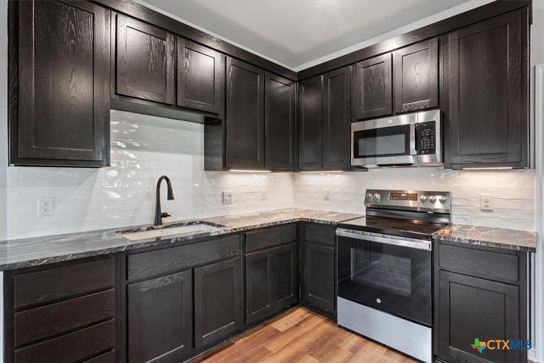 10940 Wedel Cemetery Road Rogers, TX 76569 - Photo 40 of 48 a kitchen with granite countertop cabinets stainless steel appliances and a sink